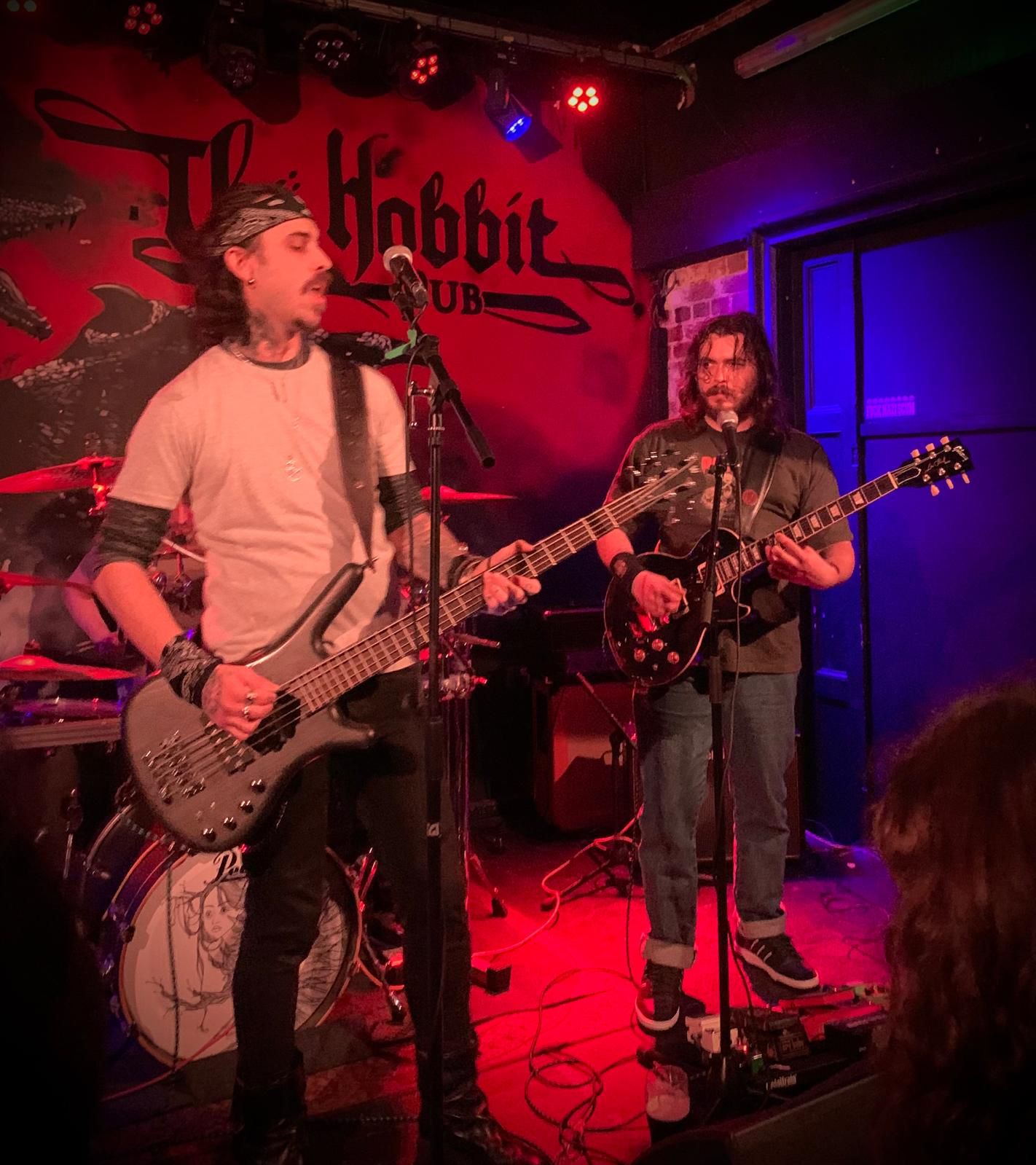 Hexblood bassist and guitarist singing together on stage at The Hobbit pub