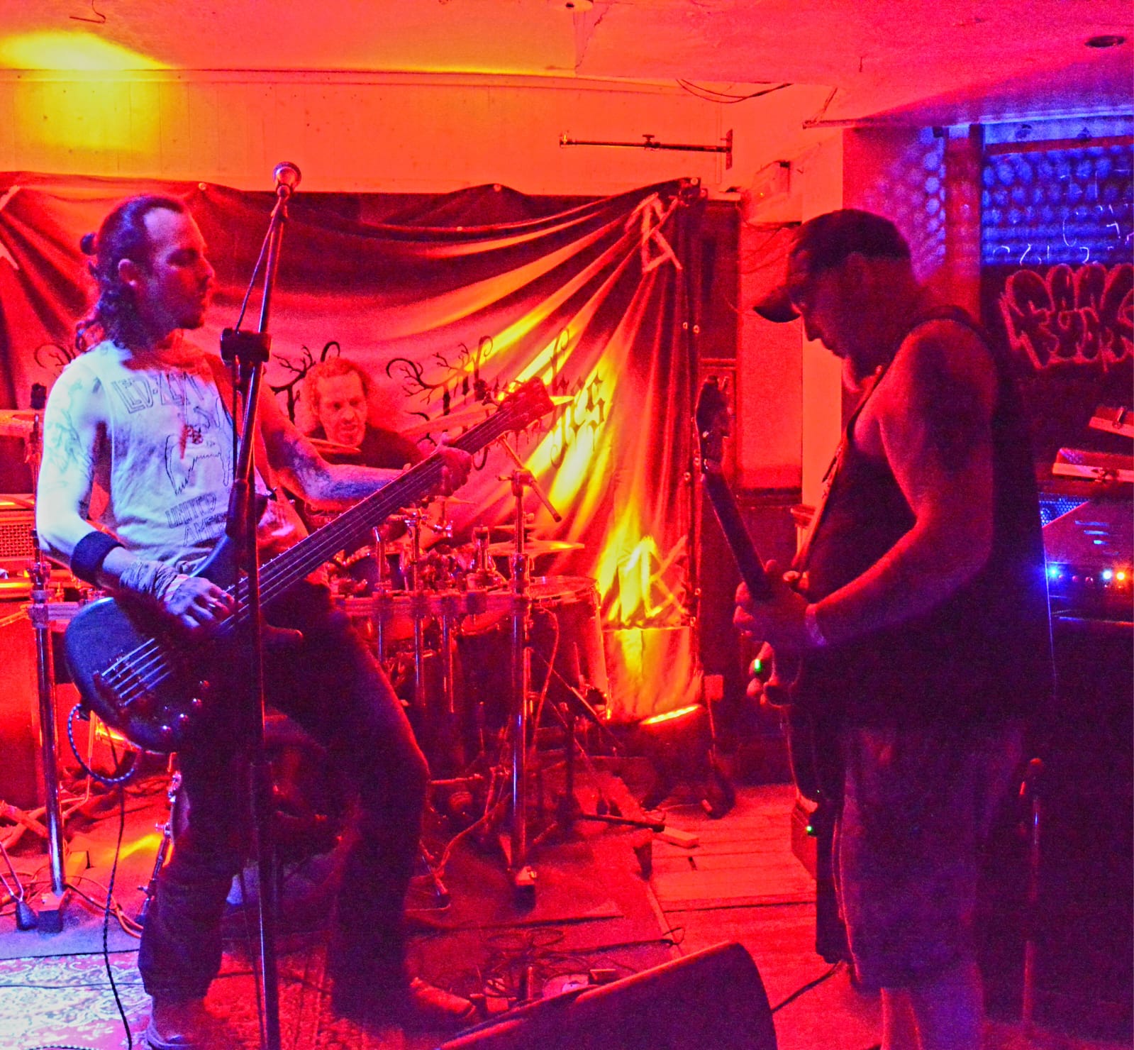 Hexblood bassist and guitarist facing off during a red-lit live set
